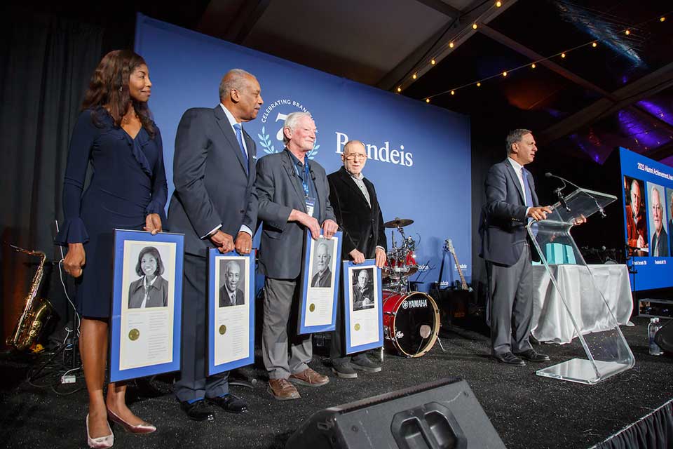 Winners of the Alumni Achievement Award stand with awards next to President Ron Liewbowitz