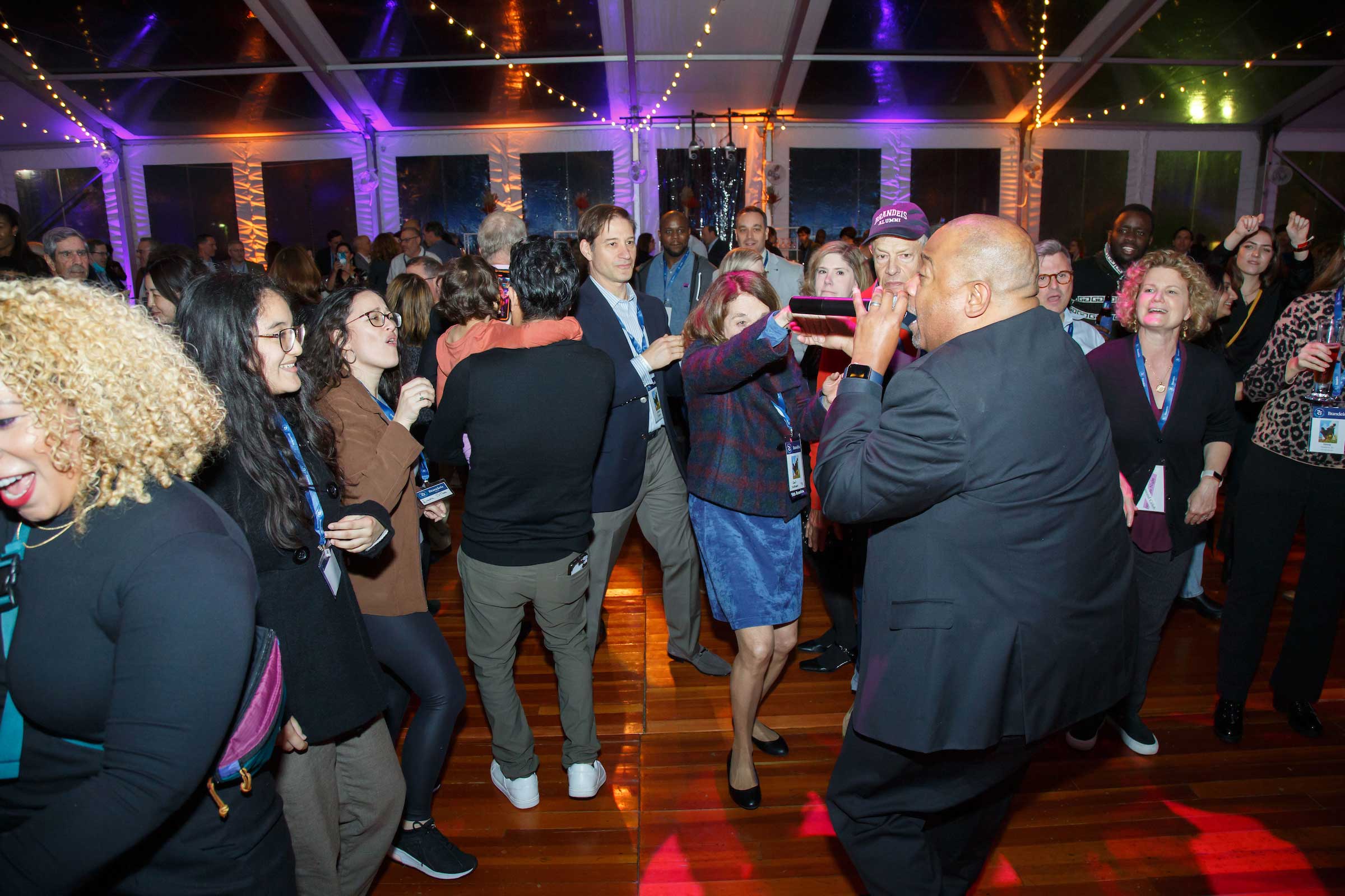 Crowd dances and sings along with band member. 