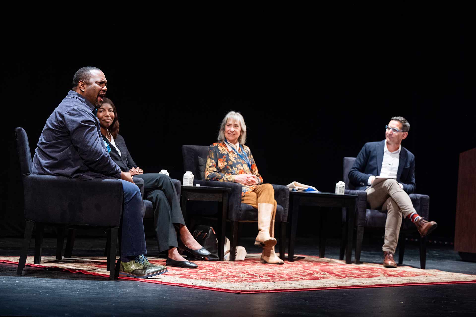 Four people talk on stage