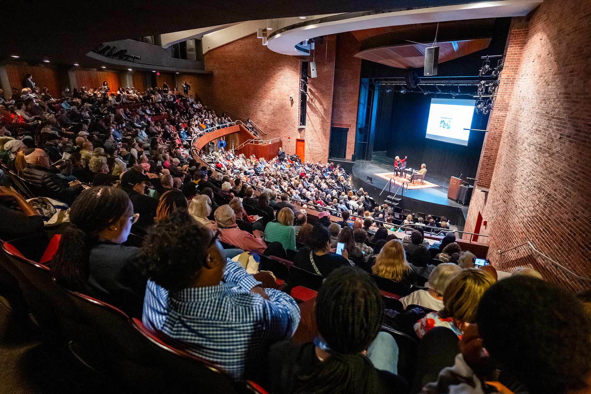 A full auditorium of attendees watching a panel discussion