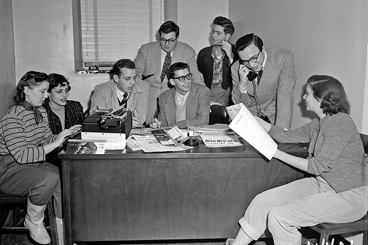 Members of the Justice Staff sit around a desk
