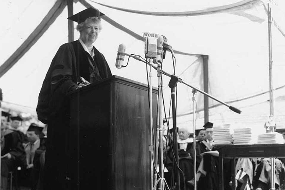 Eleanor Roosevelt stands at the podium in a cap and gown