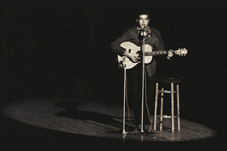 Archival photo of Bob Dylan performing on stage