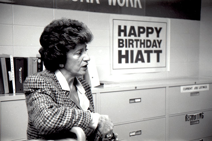 A person standing in front of a sign that says Happy Birthday Hiatt