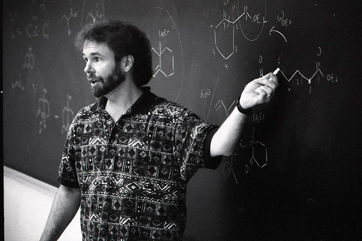 Black and white photo of a teacher at a blackboard