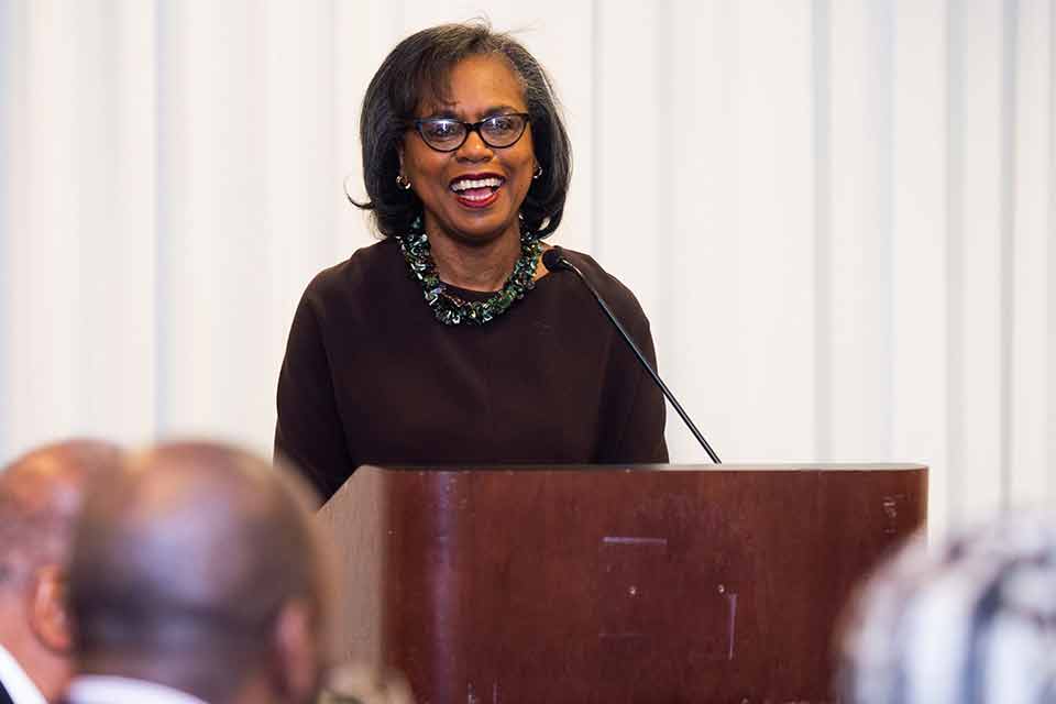 Anita Hill speaking at a podium