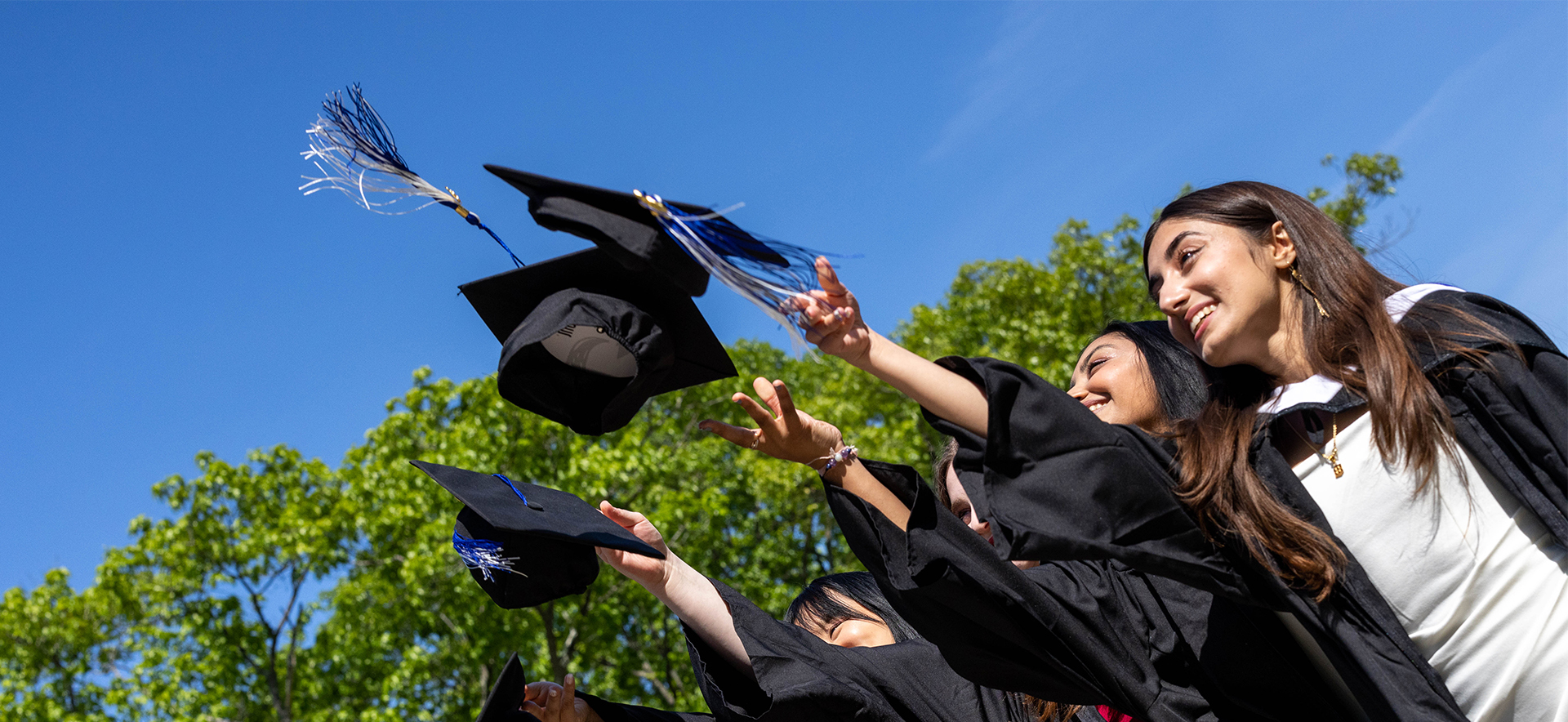 Robed alumni toss their caps in the air