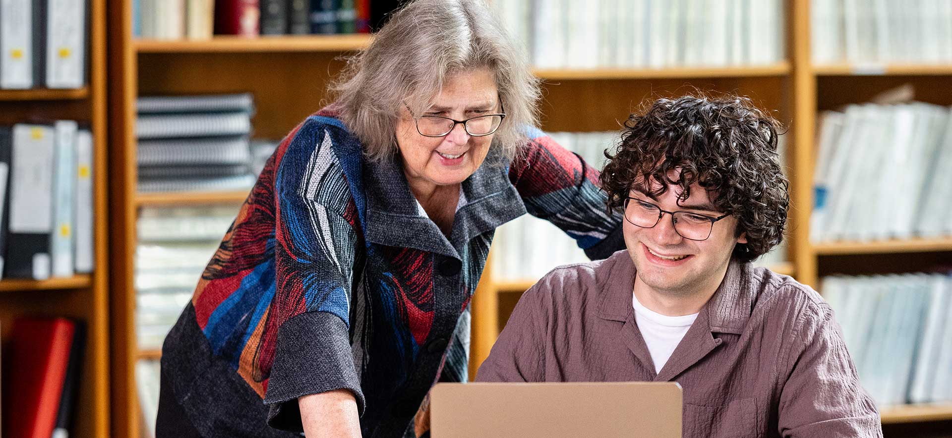 Brandeis Professor Karen Donelan works on a laptop with a student.