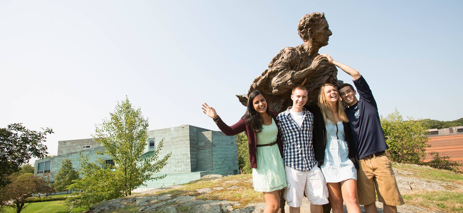 Students posing with the Statue of Justice Louis D. Brandeis on campus