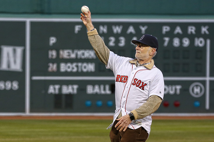 Michael Rosbash throwing a baseball, wearing a Red Sox jersey and hat