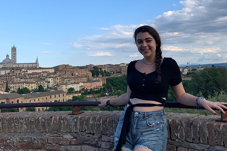 Anya standing with the city of Siena in the background.
