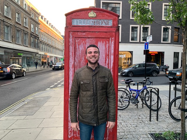Yona standing in front of a phone booth in London.