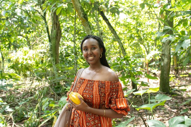 Salma Ahmed smiling with green leafy trees behind her.