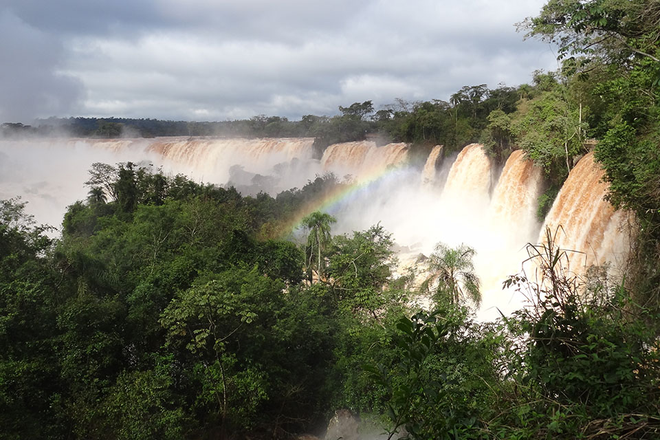 A large waterfall with a rainbow overhead