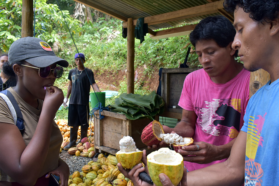 A student tasting fruit from a local vendor