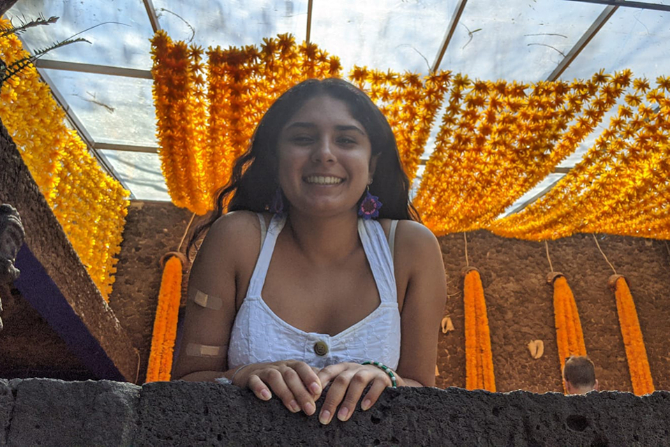 A student looking over the railing and smiling