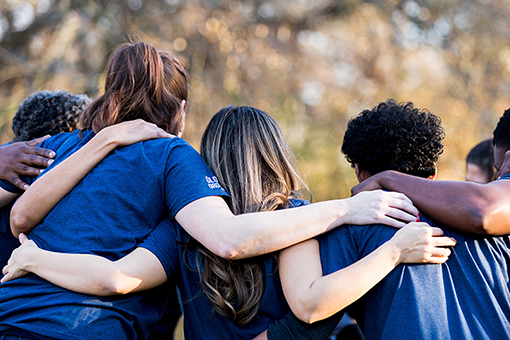 Students clasp arms from behind