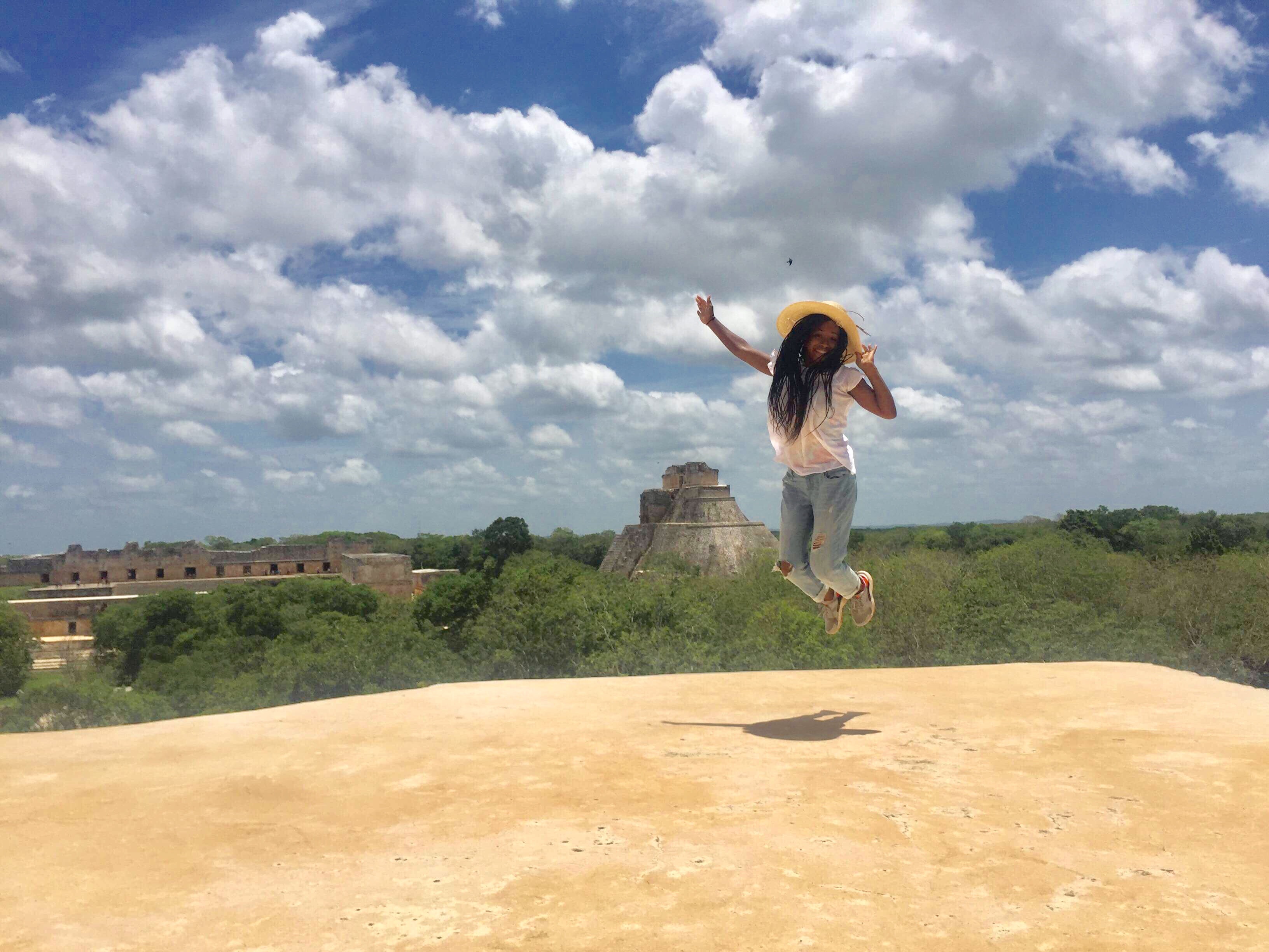 Student jumping in front of landscape in Merida.
