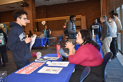 Two students talk at the Gen One resource fair.