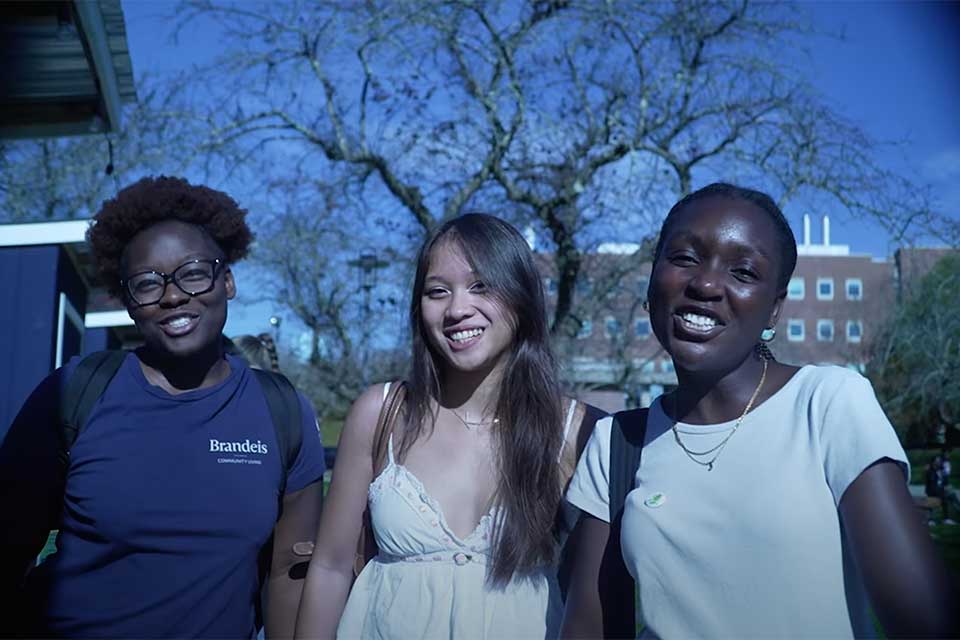Three students smile at the camera