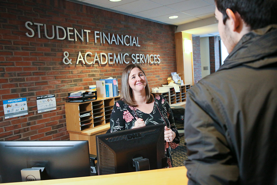 A student is greeted at the Academic Services front desk