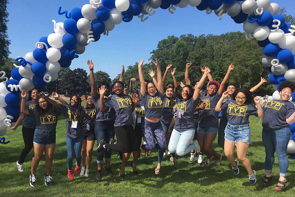 MKTYP students jumping below a balloon arch