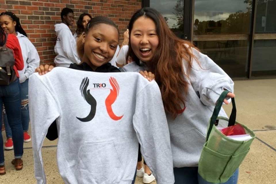 Students holding up their t-shirt together