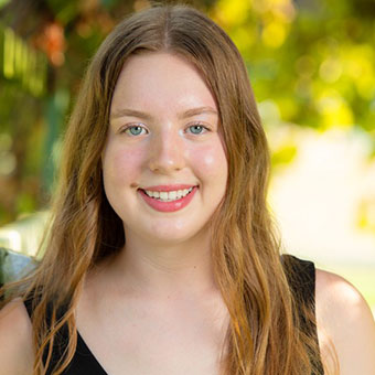 A headshot of Abigail. A woman with dirty blond hair and blue eyes smiling at the camera.