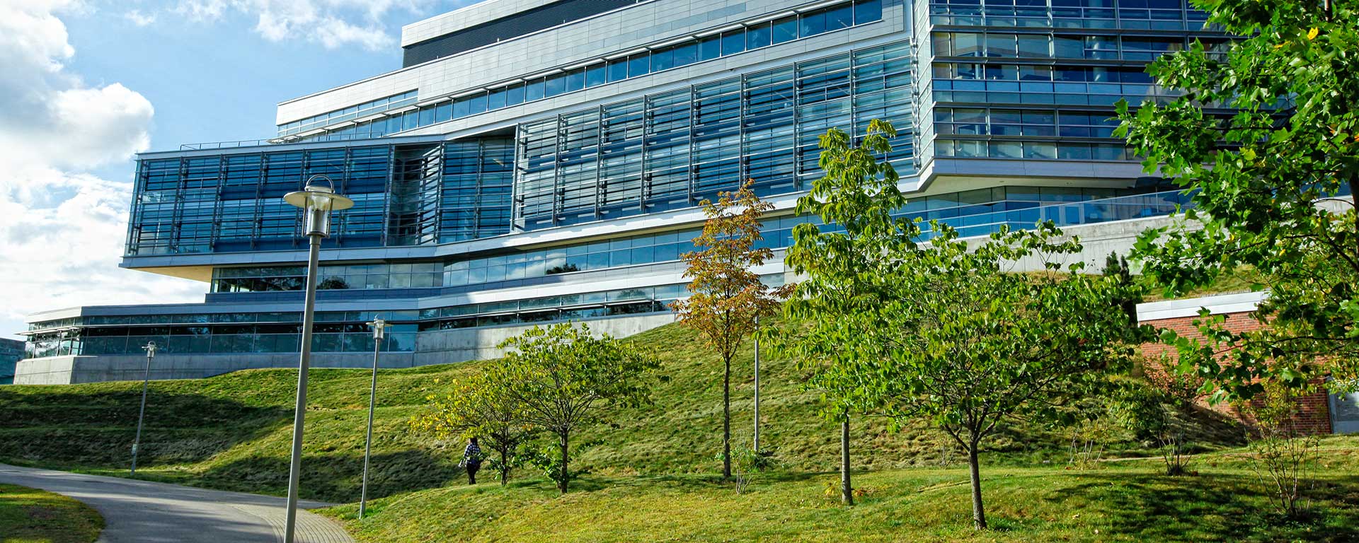 lone student walks past science center on bright spring day