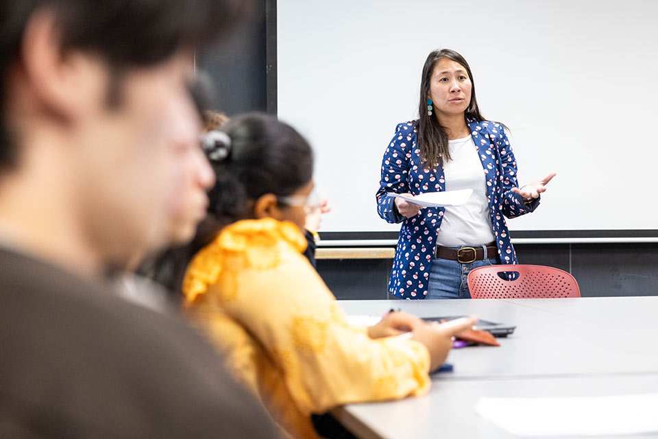 Professor Jill Greenlee sits and talks with students during class