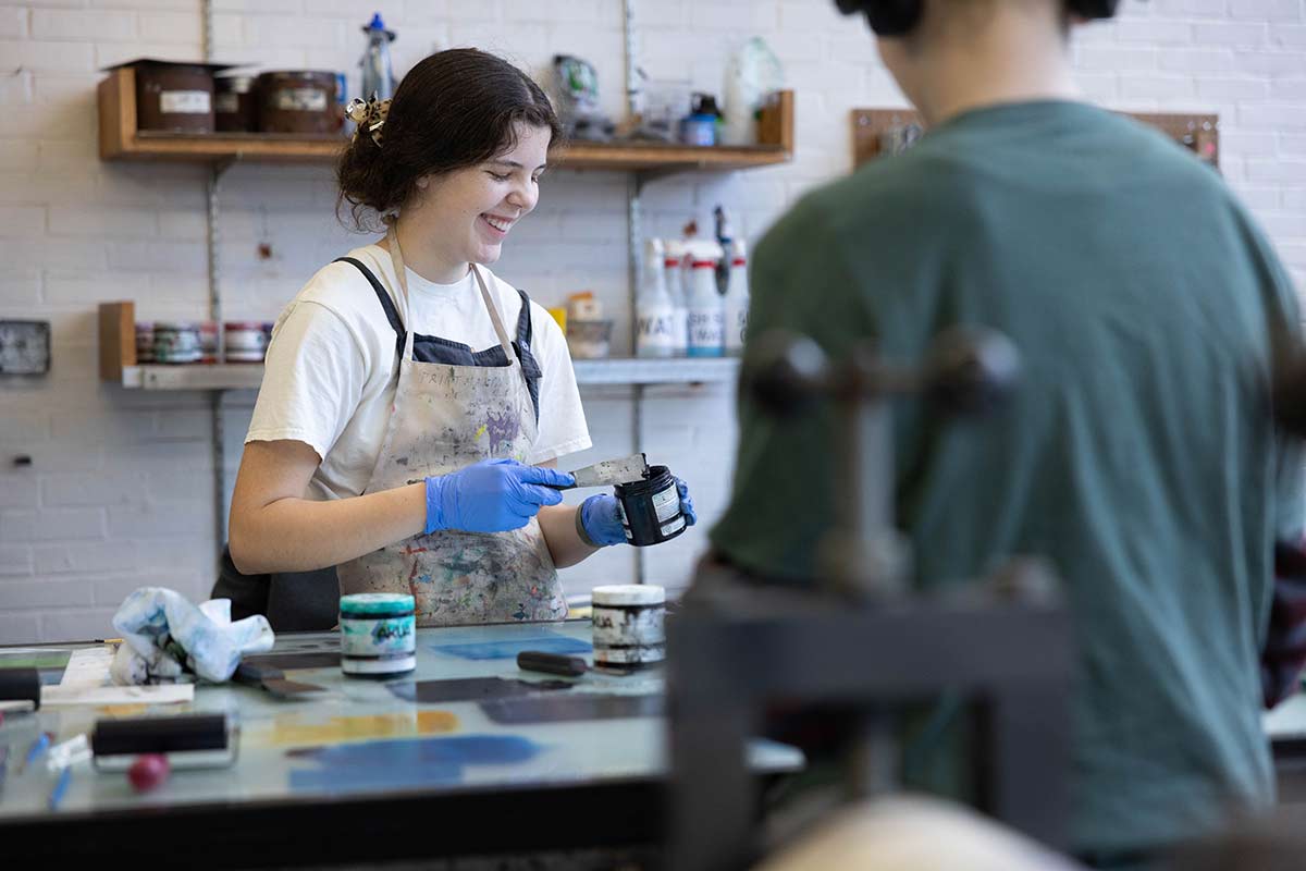 A student paints in a studio