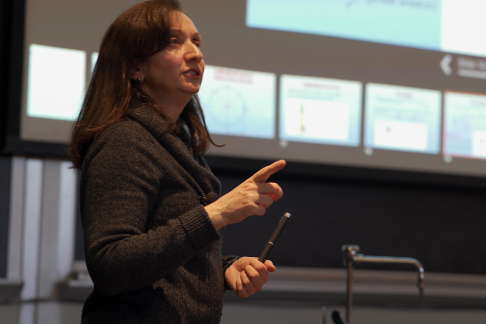 Gabriella Sciolla standing and speaking in front of a classroom projection screen