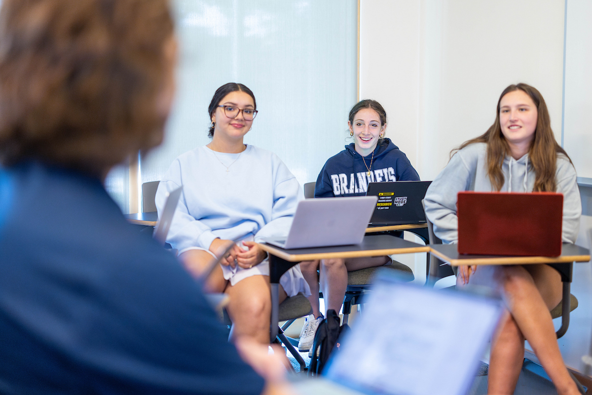 Three students smile during a Hispanic Studies class on campus