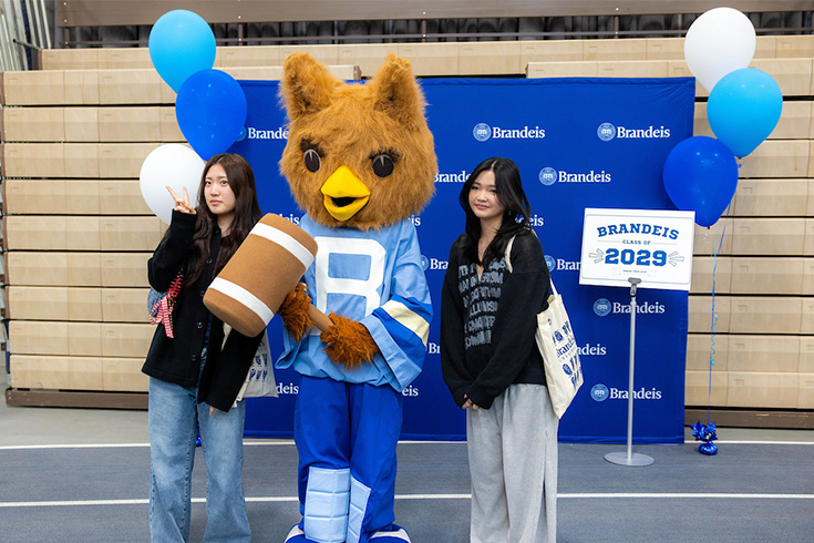 Two students pose with an owl mascot