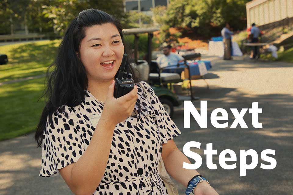 Five happy students sitting against a brick wall, with text that reads, "Next Steps"