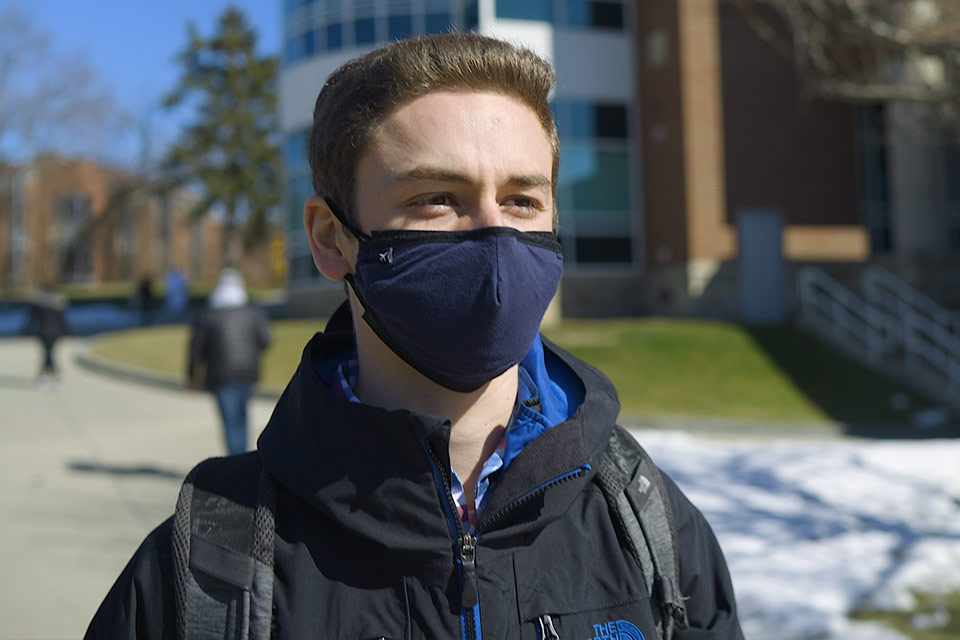 Matthew standing outside with a mask on.
