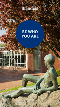 A statue of a reclining person in front of the library with text that reads Be who you are. Brandeis