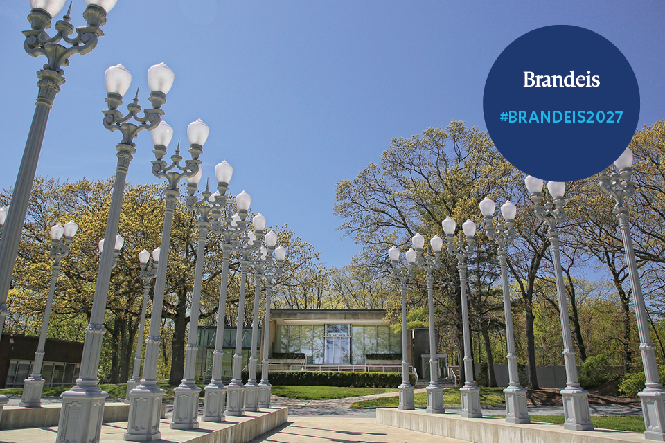 The Light of Reason sculpture in front of the Rose Art Museum with text that reads Be The Change. Brandeis.