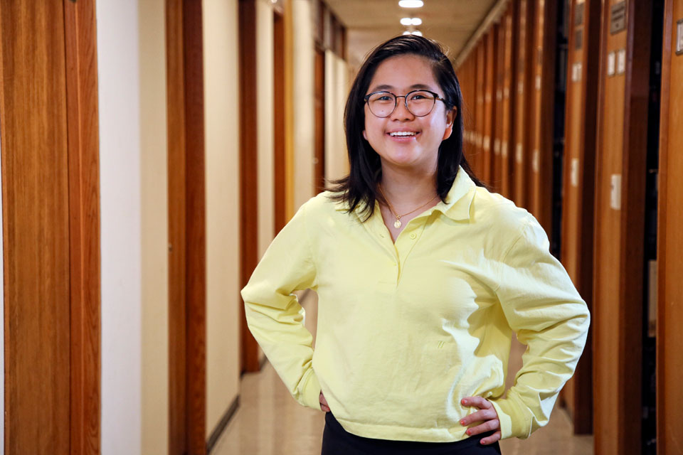 Karin smiling at the camera, standing in a hallway