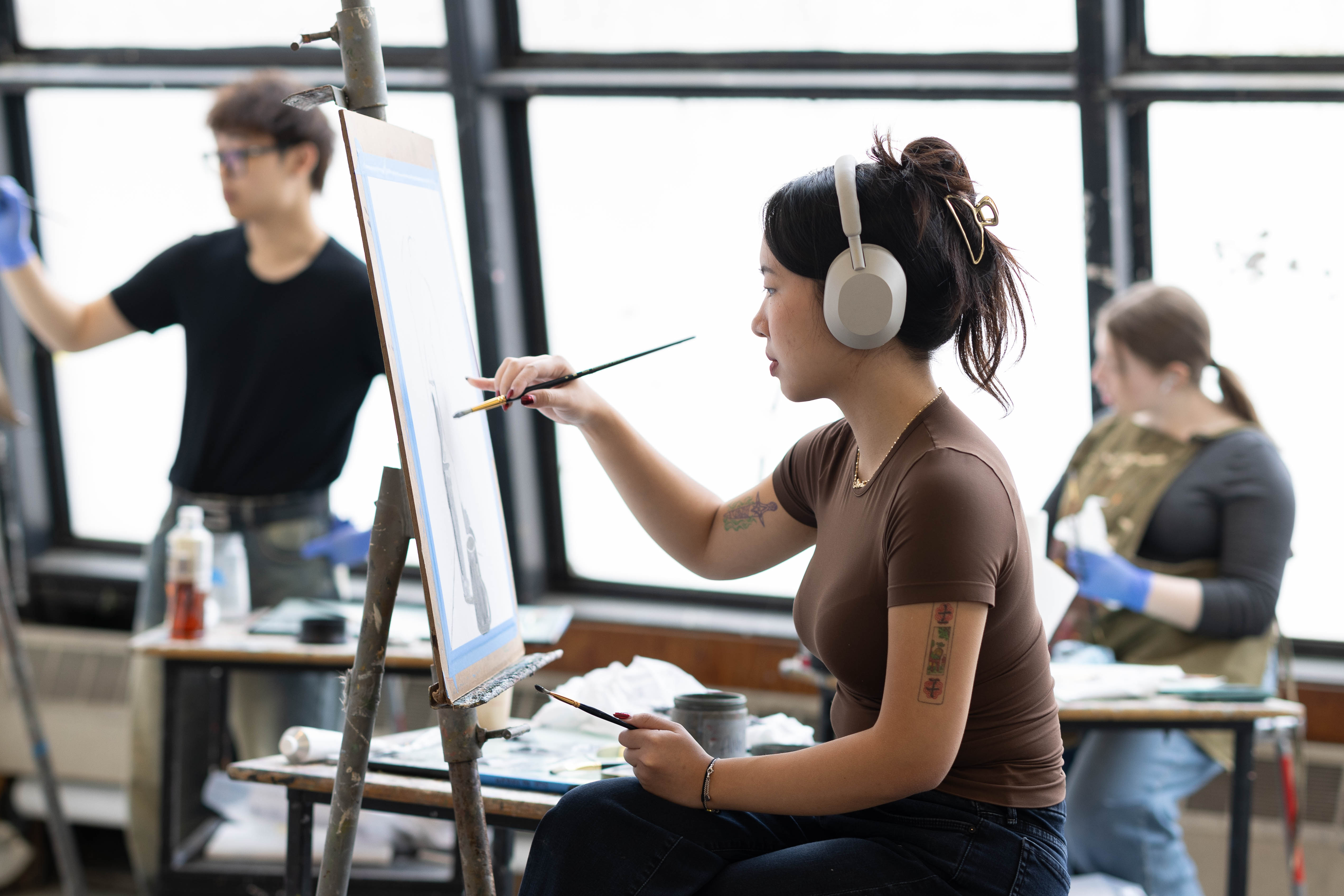 A student paints on an easel during class.