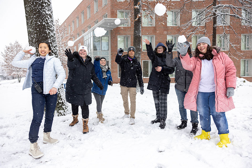 Group of students throwing snowballs at the camera