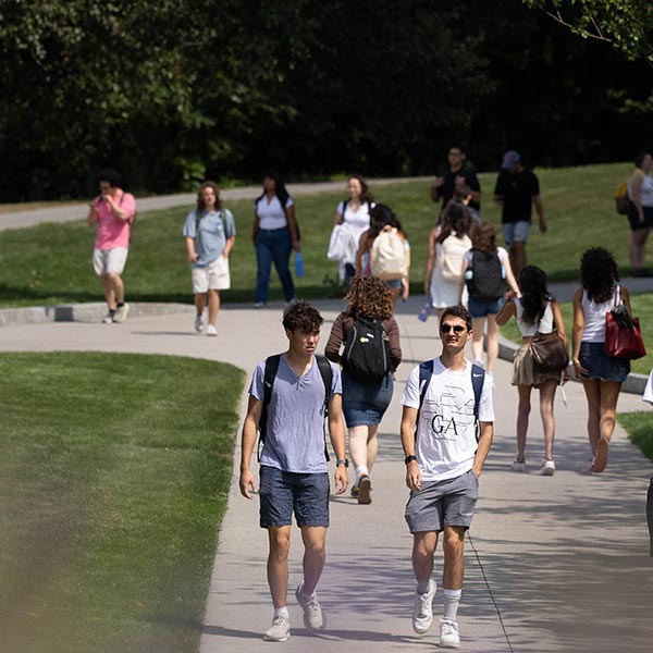 Two smiling students looking at a phone