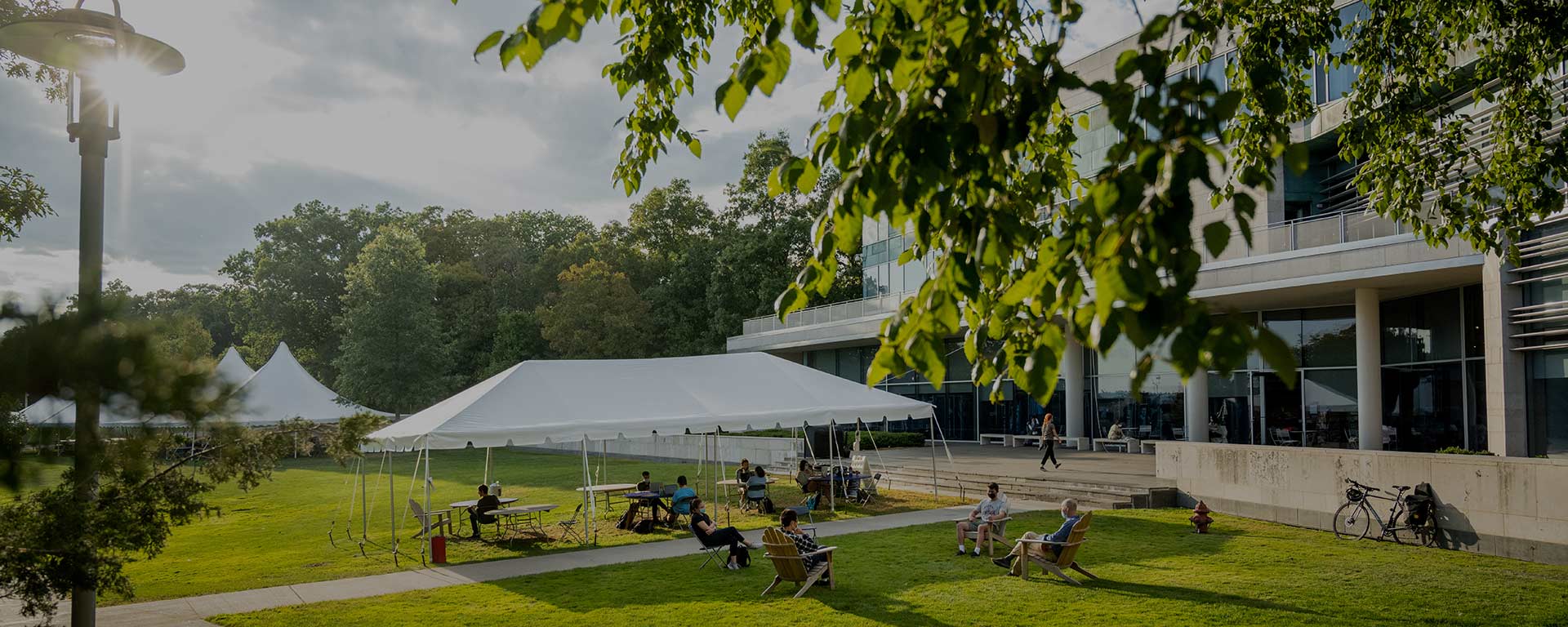 People physically distanced in chairs and under open-air tents on the Great Lawn