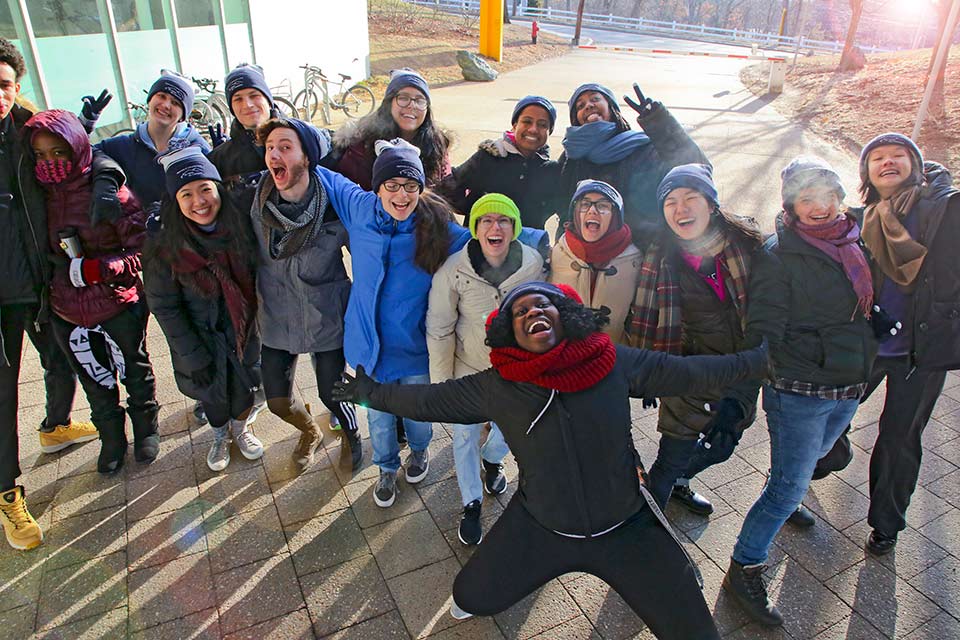 Group of students smiling for the camera, dressed in winter attire