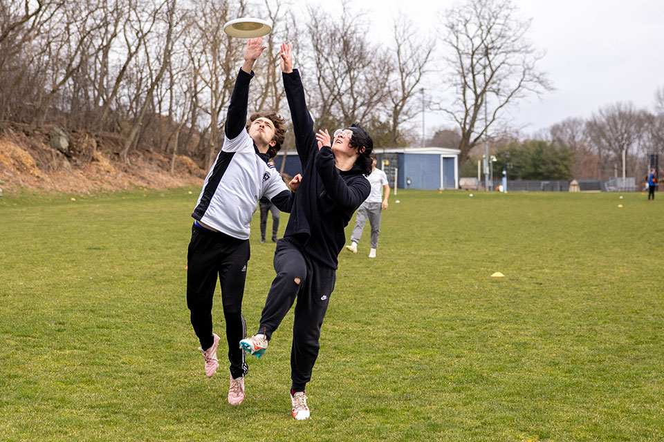 Two students play frisbee.