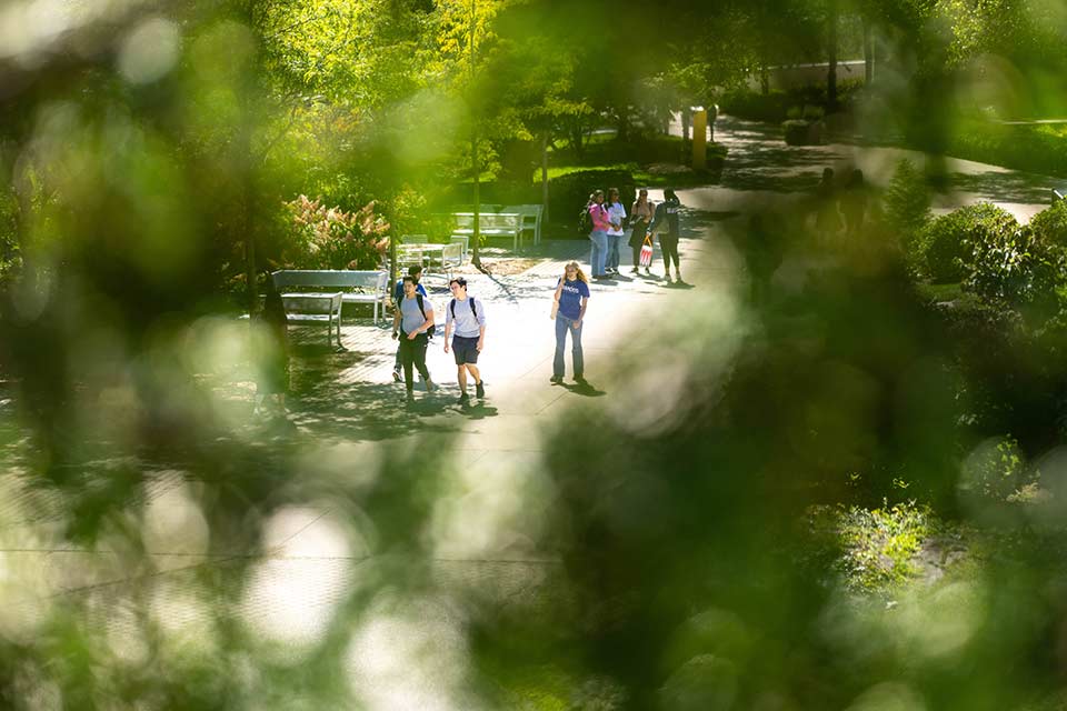 Students in masks stand socially distanced in front of Skyline Residence Hall