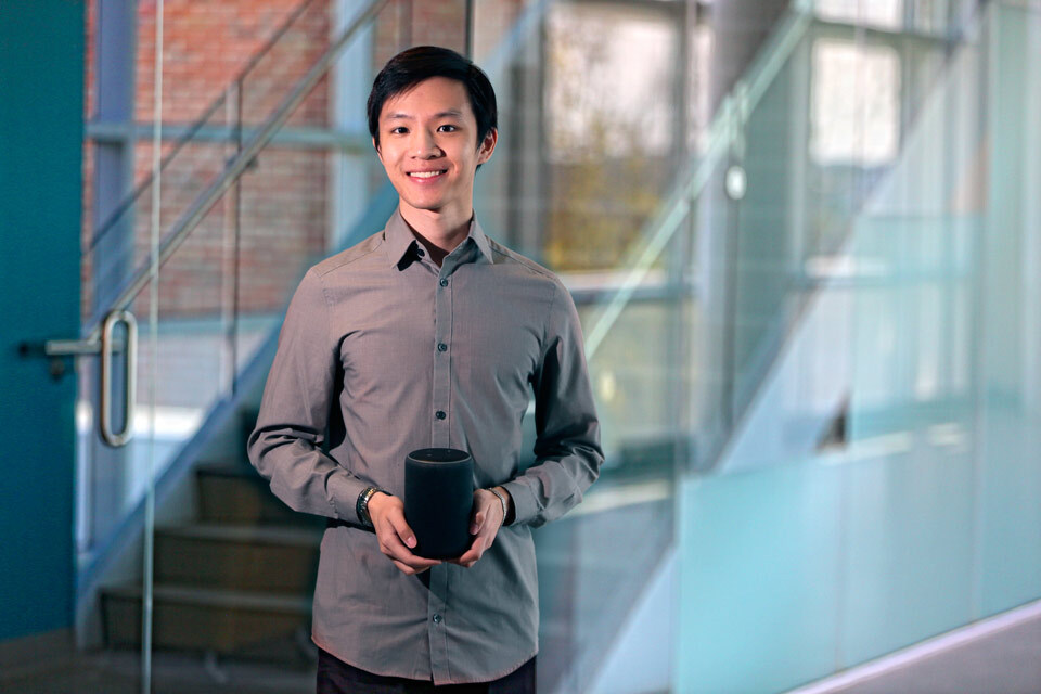 Michael Leung holding an Amazon Echo device