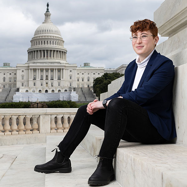 Sage sitting on steps with the U.S. Capitol building in the background