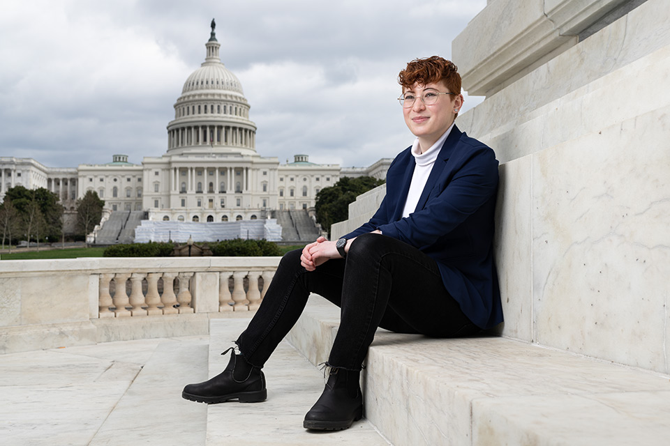 Sage sitting on the steps with the U.S. Capitol building in the background