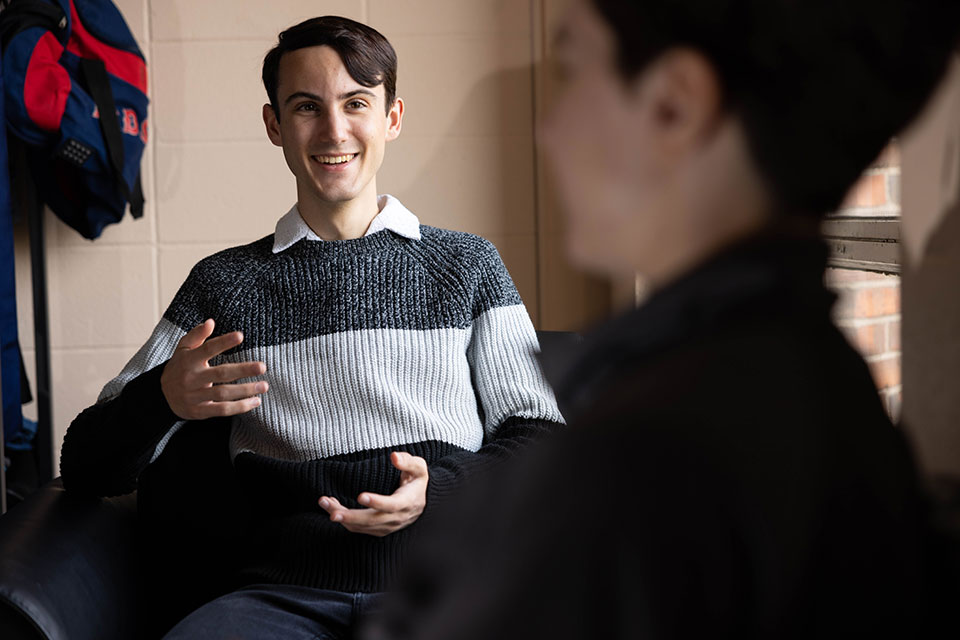 Cameron smiles while talking to another person